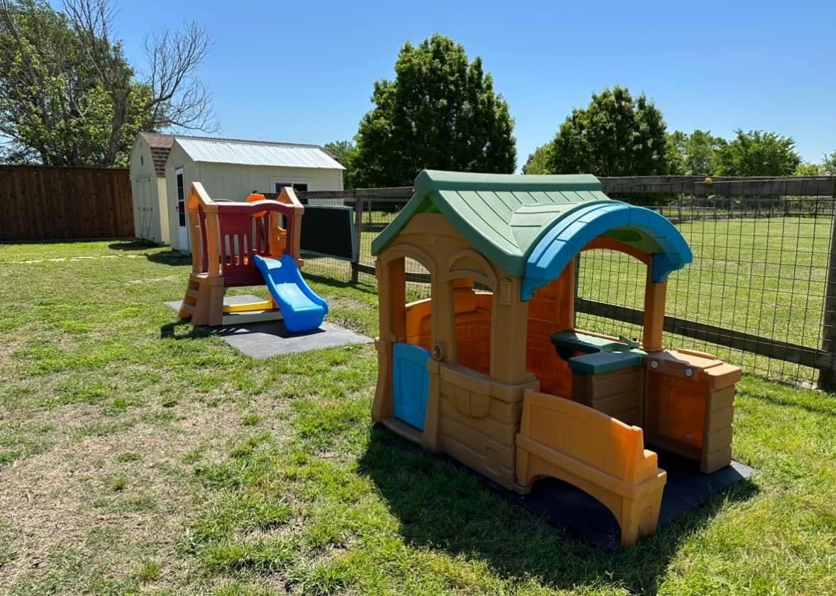 Playhouse and slide in a grassy yard