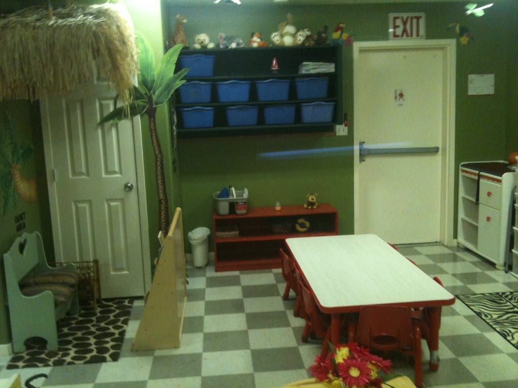 Classroom with small tables and chairs, storage, and two doors