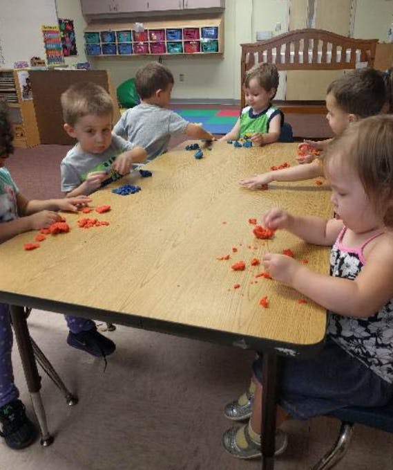 Children playing with modeling clay at a table