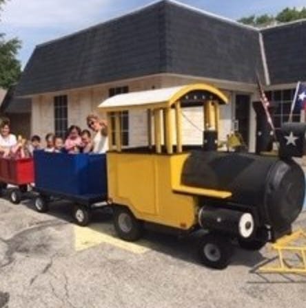 People and children riding in a small train
