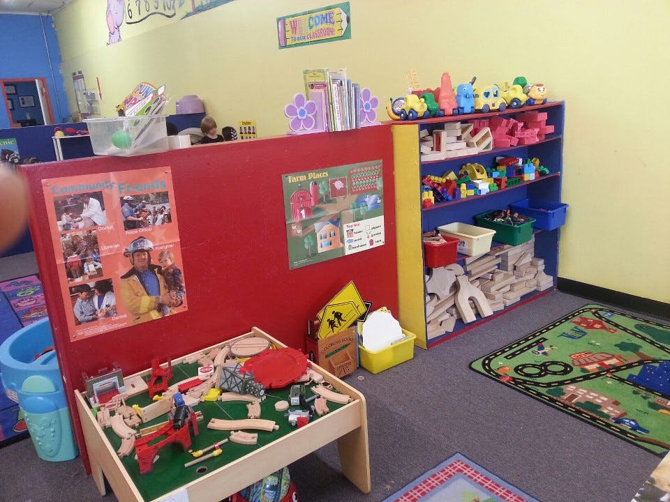 Playroom with a toy train table and shelves of toys