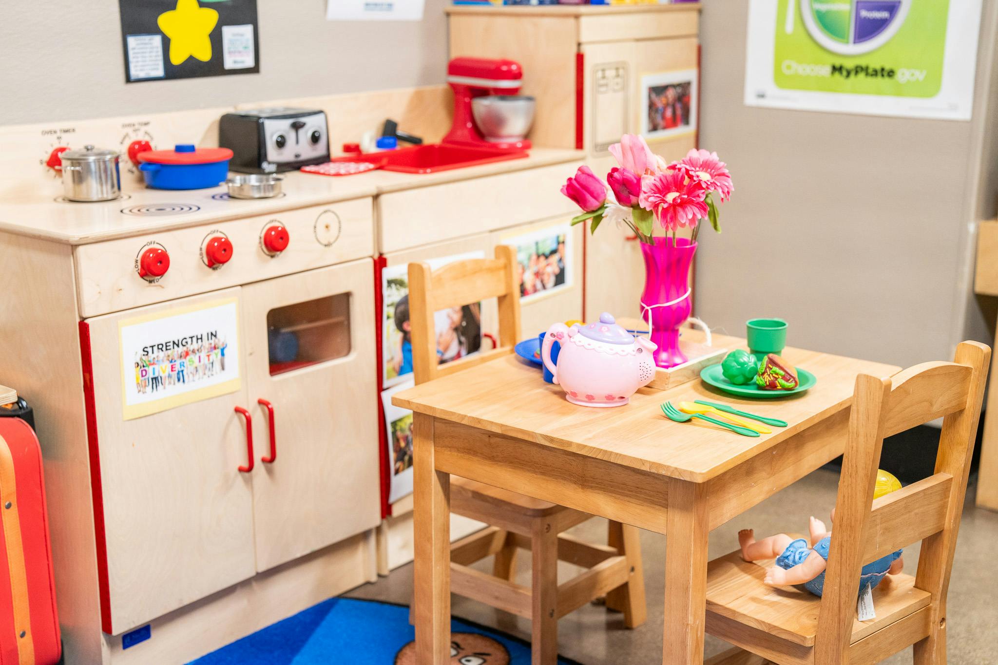 Toy kitchen set with a small dining table, chairs, and play food