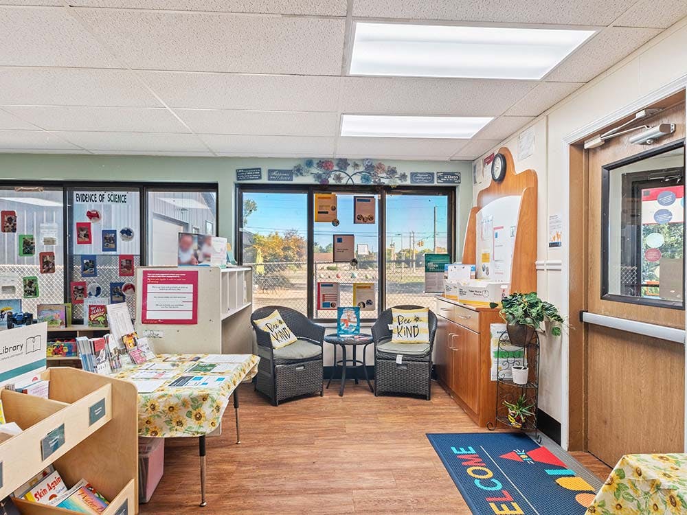 Children's classroom with books, chairs, and signs including "EVIDENCE OF SCIENCE"