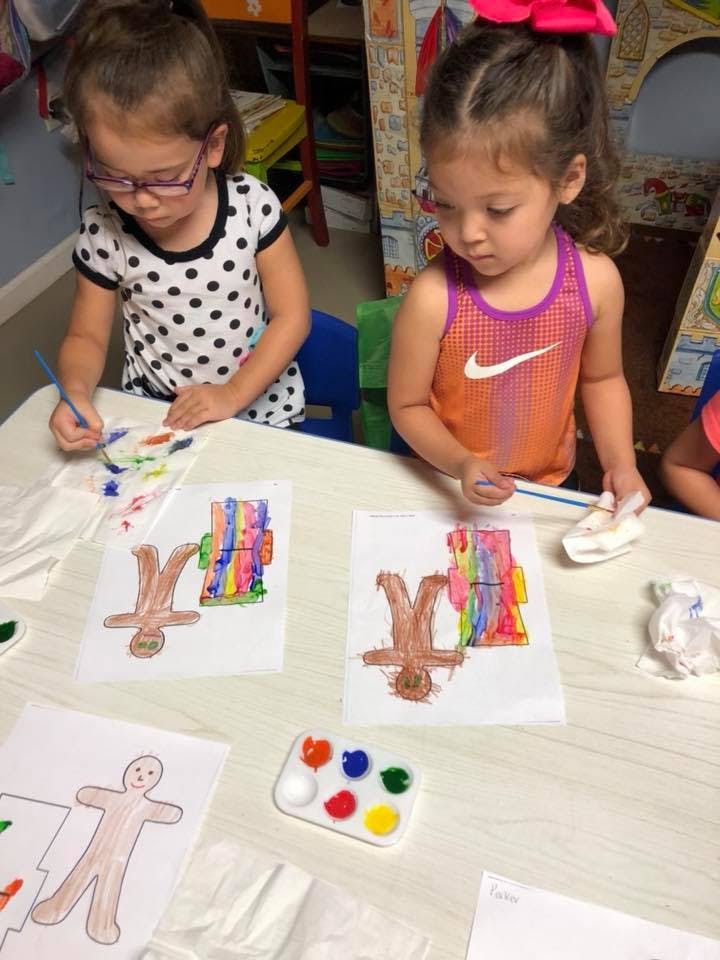 Two children painting at a table