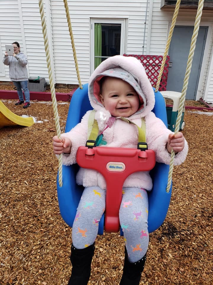 Child in a blue swing on a playground