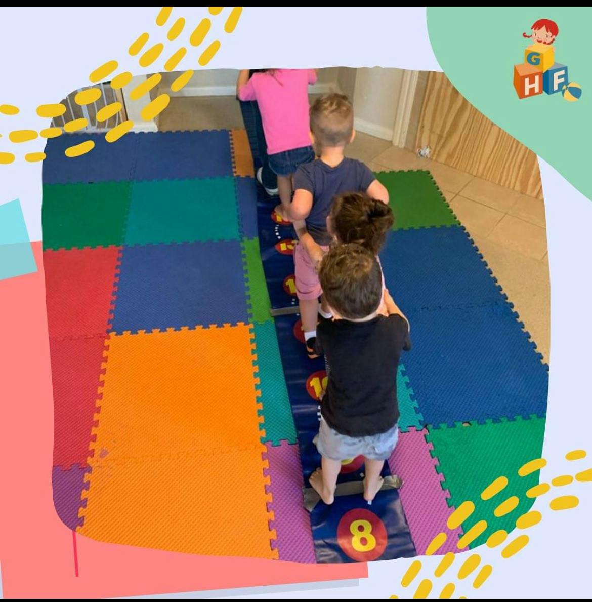 Four children playing on a number mat in a line