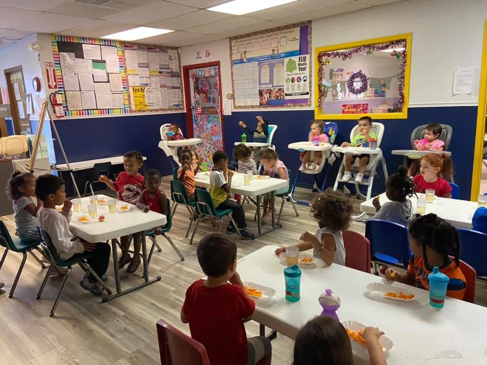 Children and teens sitting at tables in a classroom
