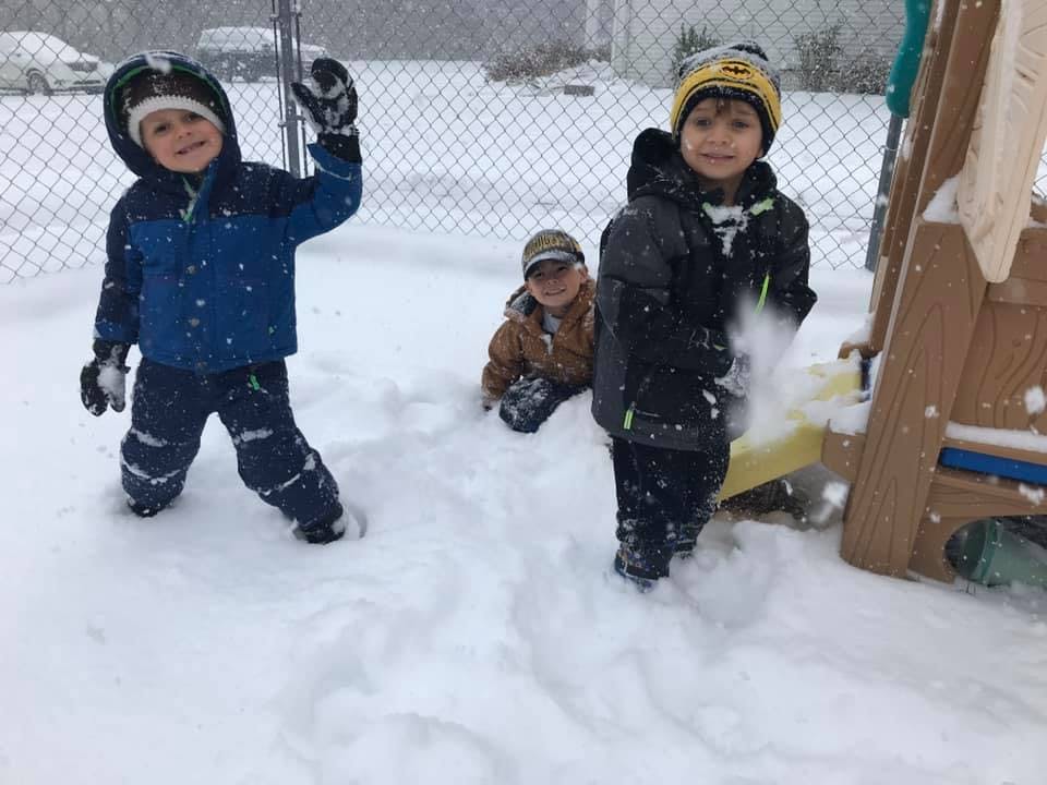 Three children playing in the snow