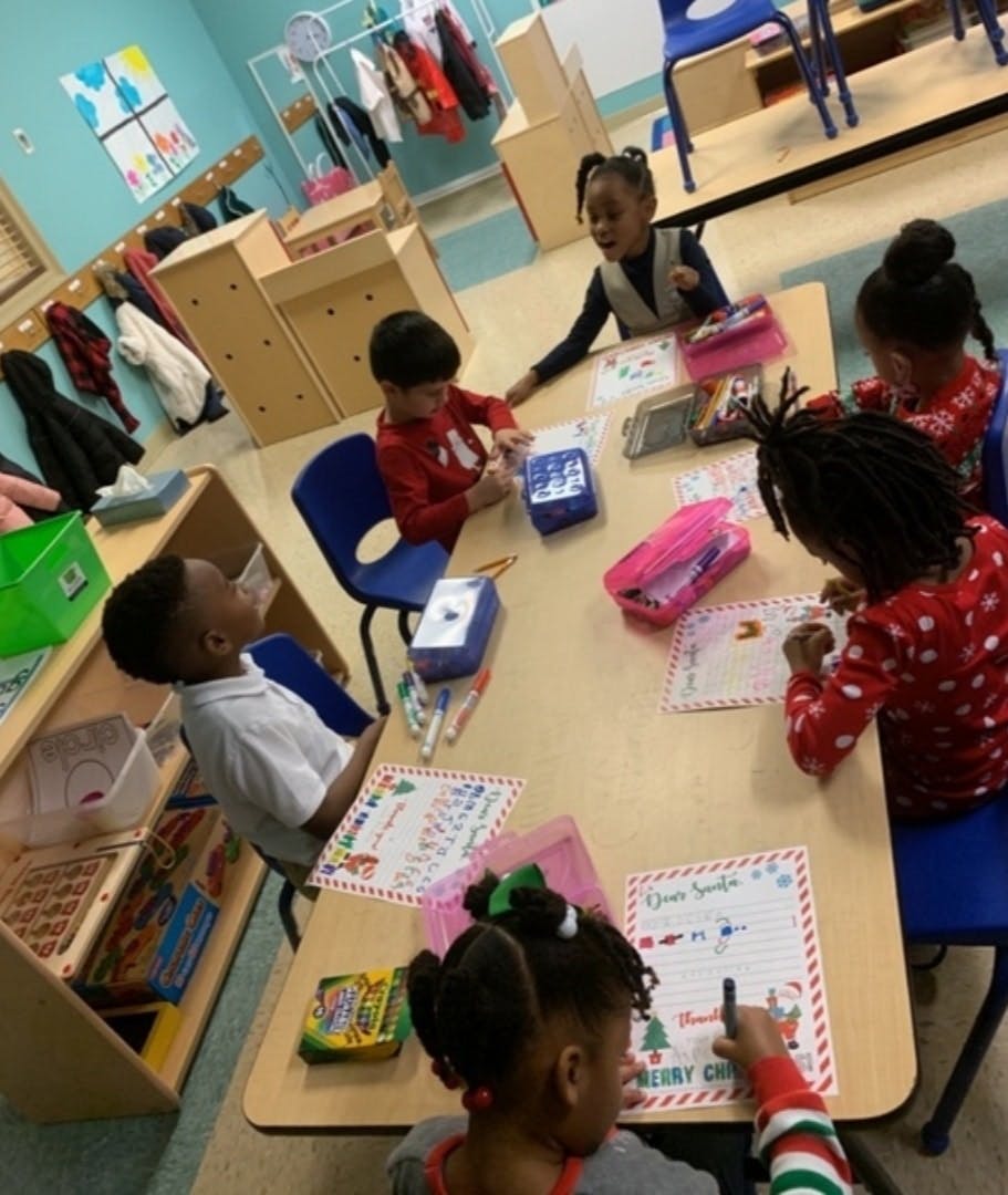Children sitting at a table doing an activity in a classroom
