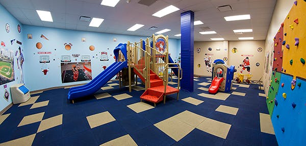 Indoor playground with slides, stairs, and a climbing wall