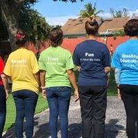 Four people standing with their backs to the camera