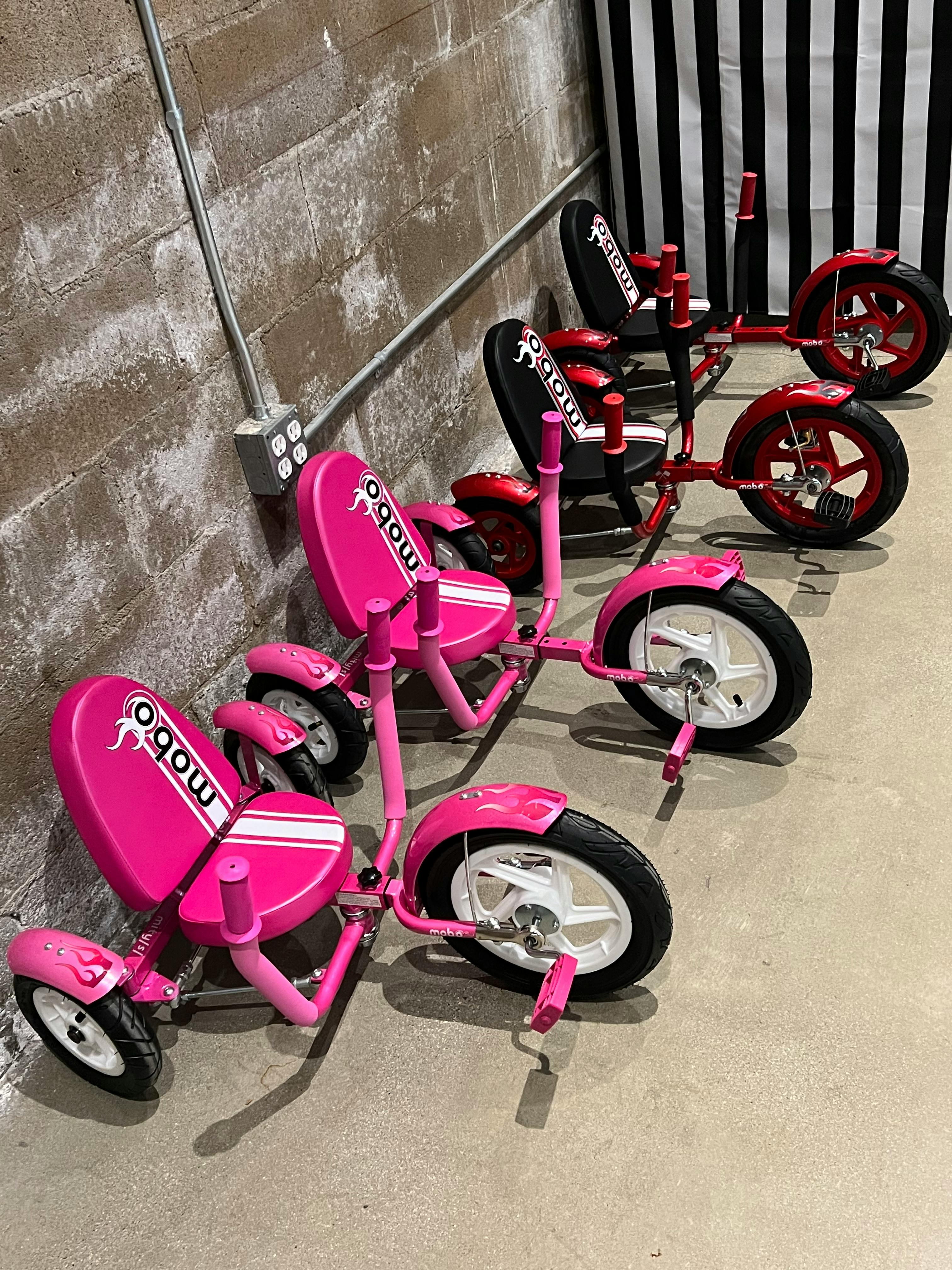 Row of pink and red recumbent tricycles