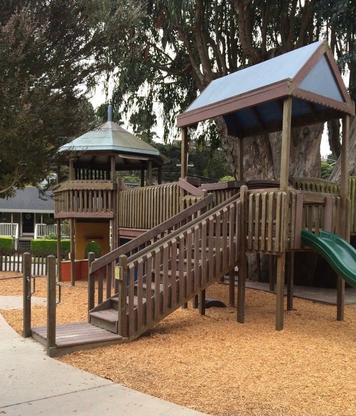 Wooden playground structure with stairs and a slide