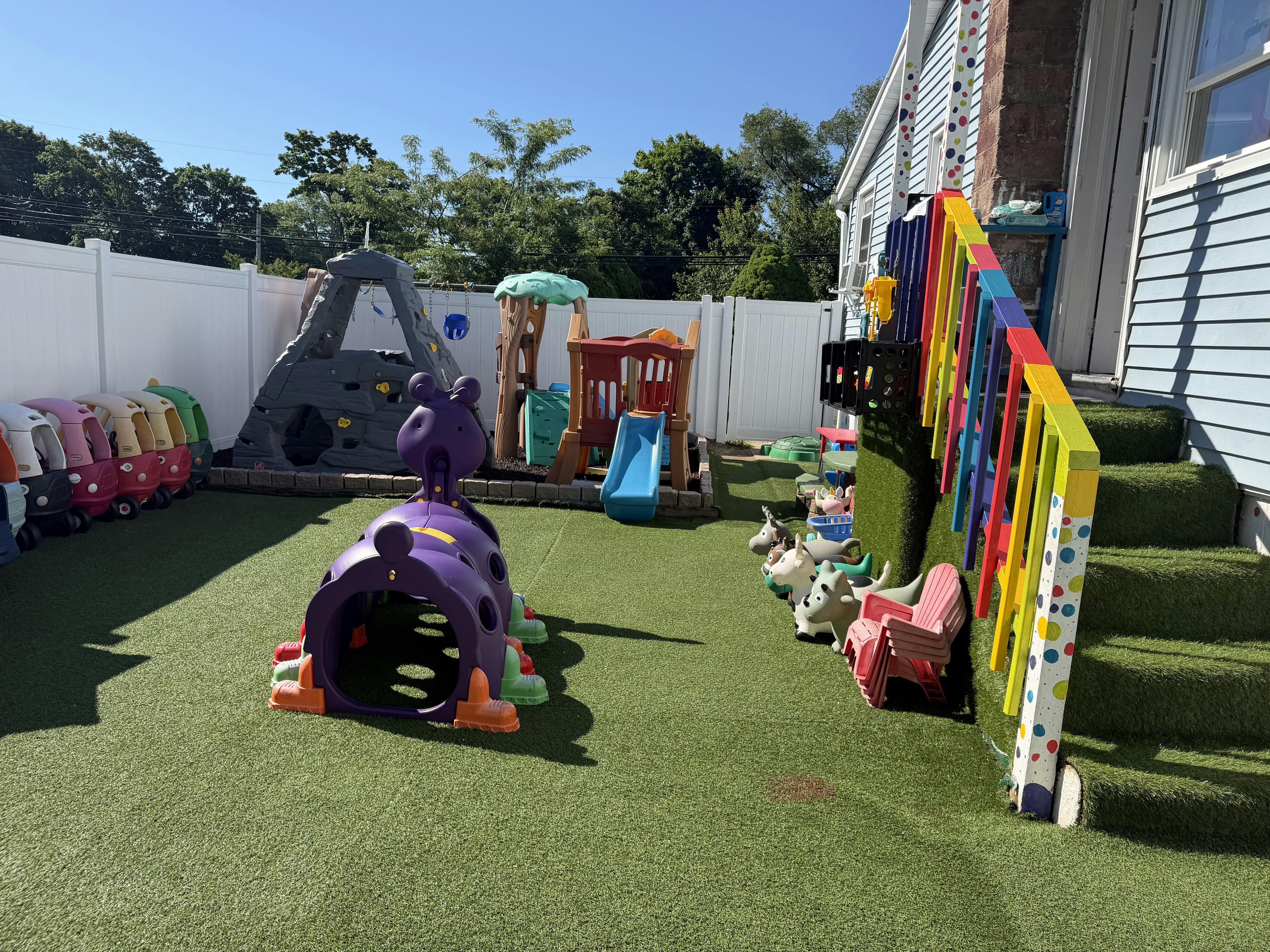 Colorful playground equipment in a backyard with artificial grass