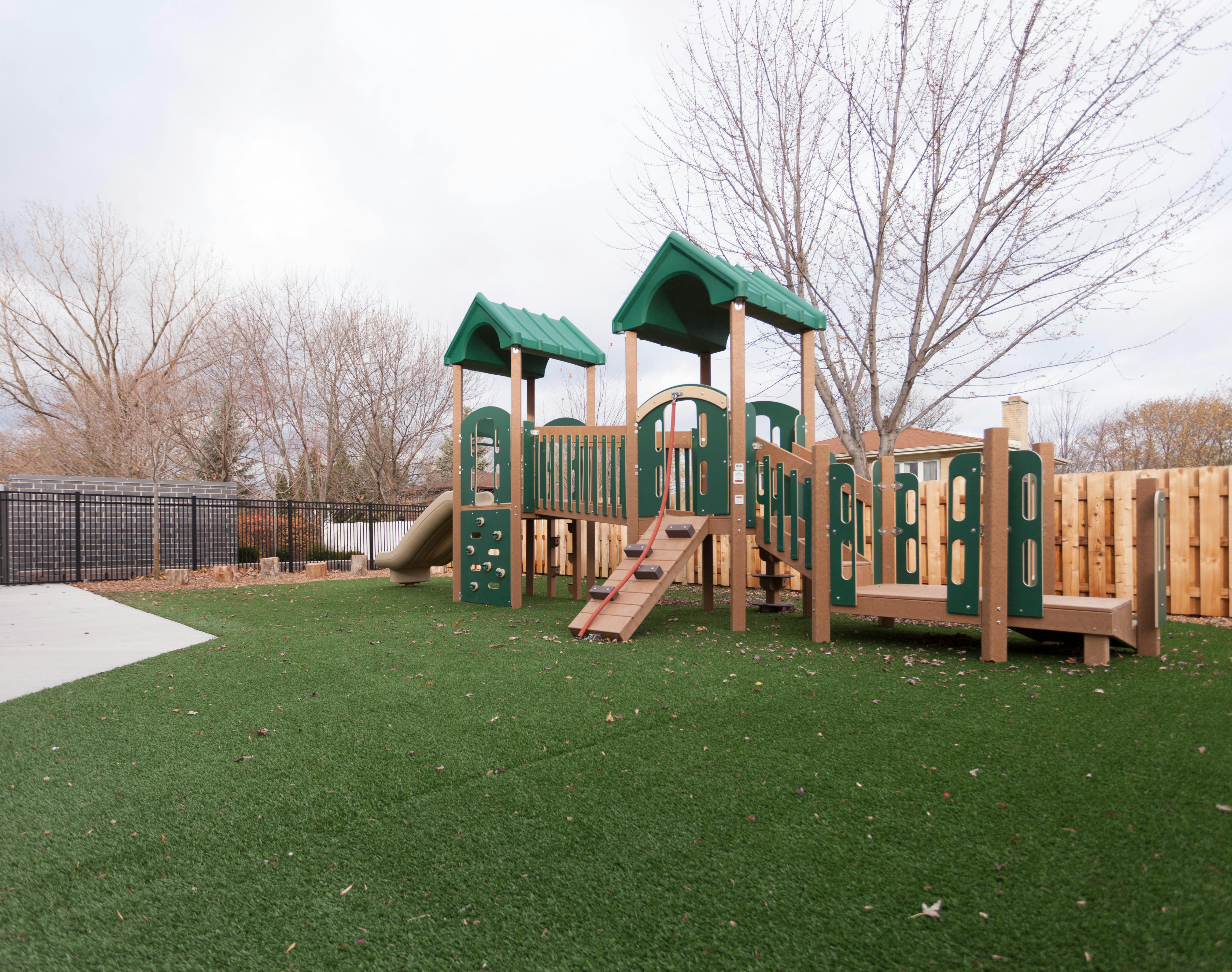 Playground structure with green roofs on artificial turf