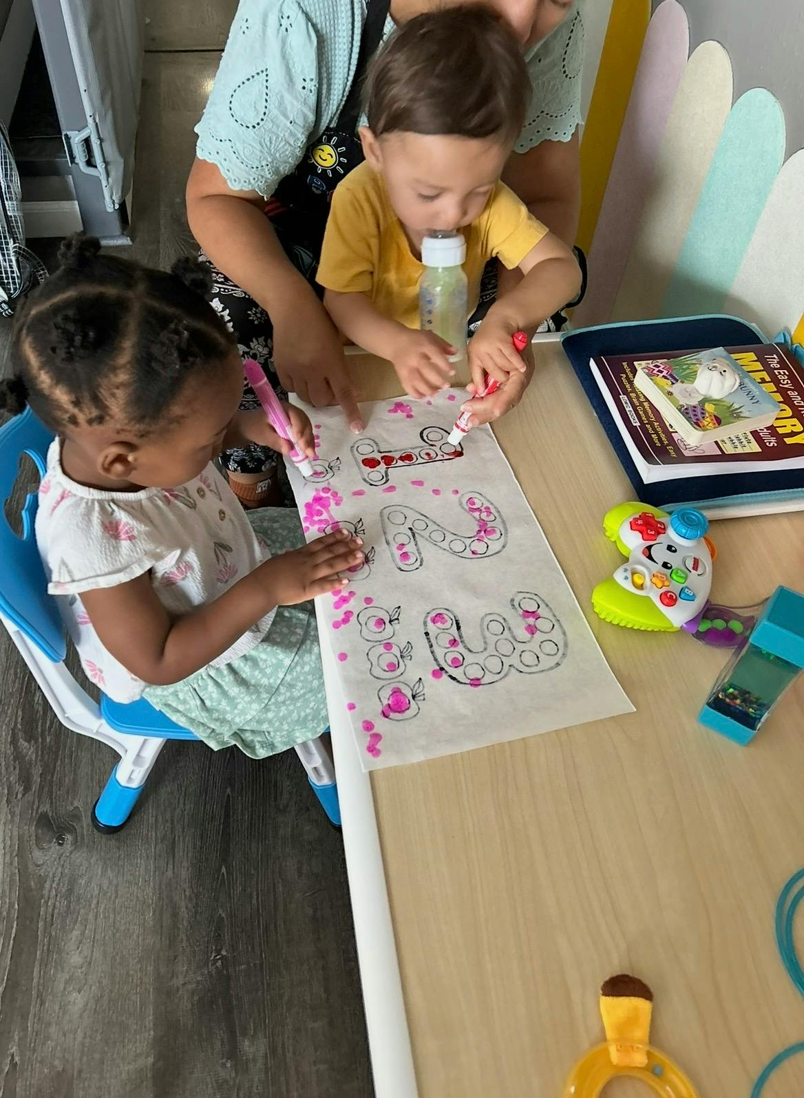 Two children coloring numbers on a worksheet at a table