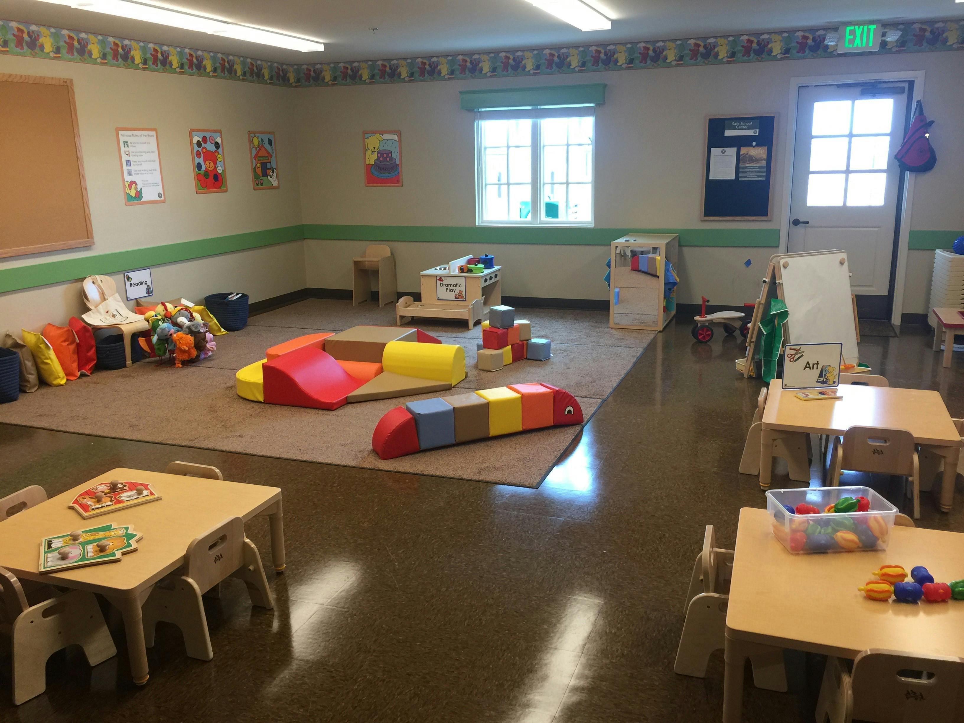 Playroom with colorful soft play equipment and small tables