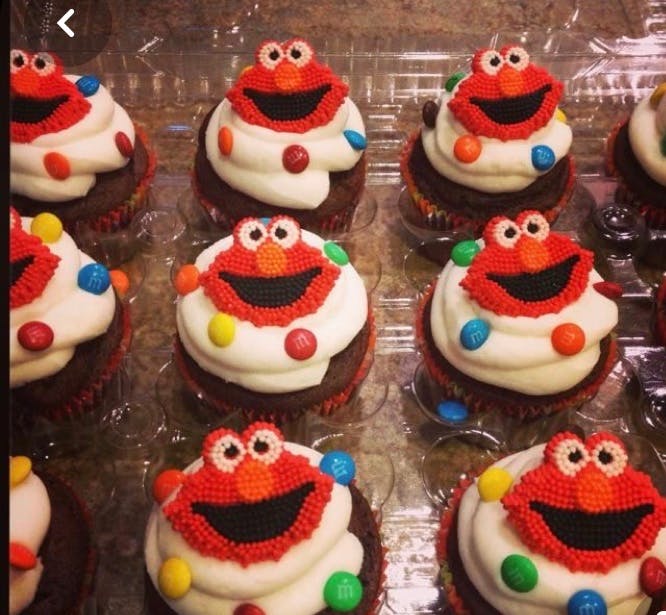 Cupcakes decorated with red frosting faces and colorful candies
