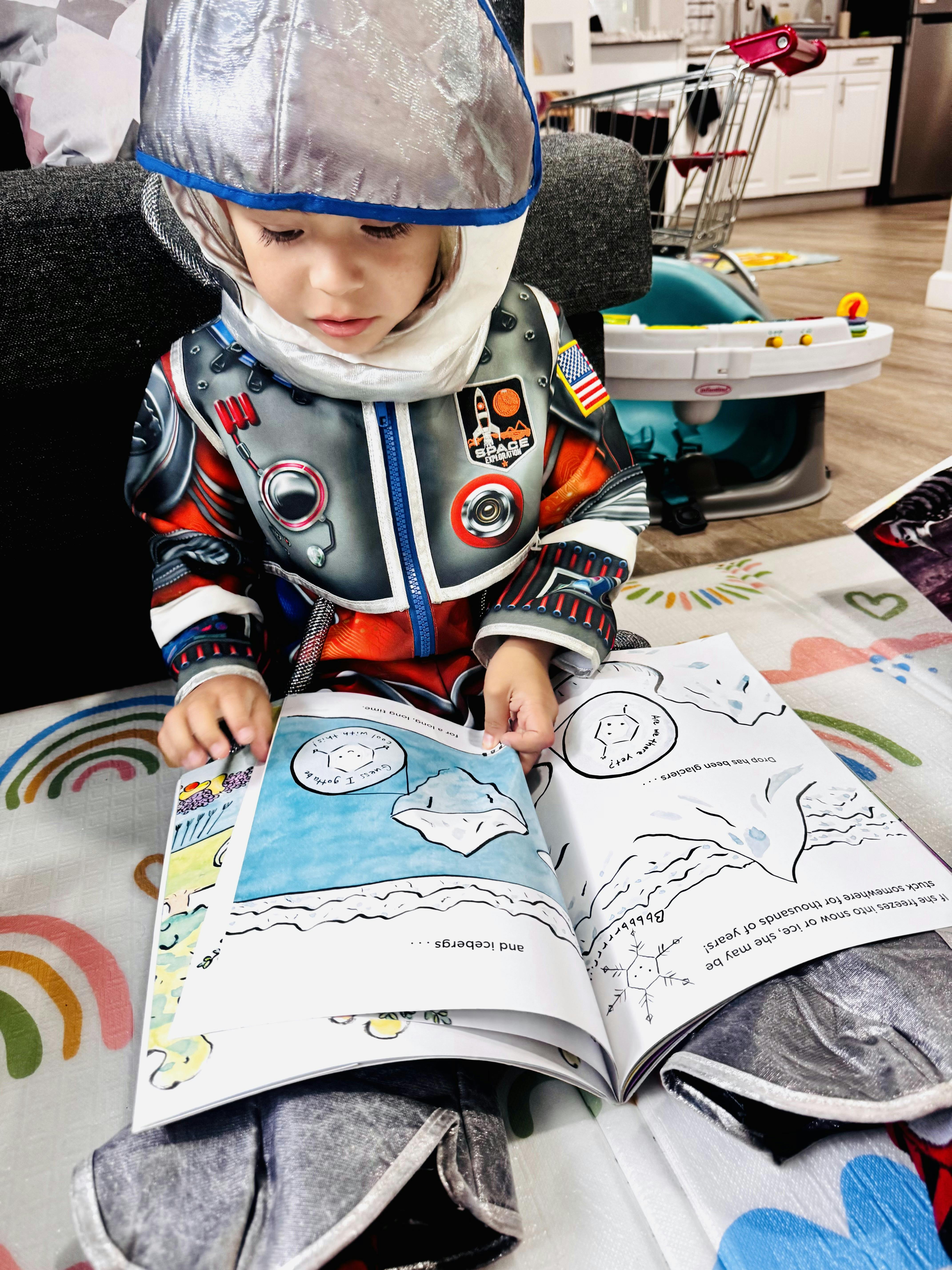 Child in astronaut costume reading a book