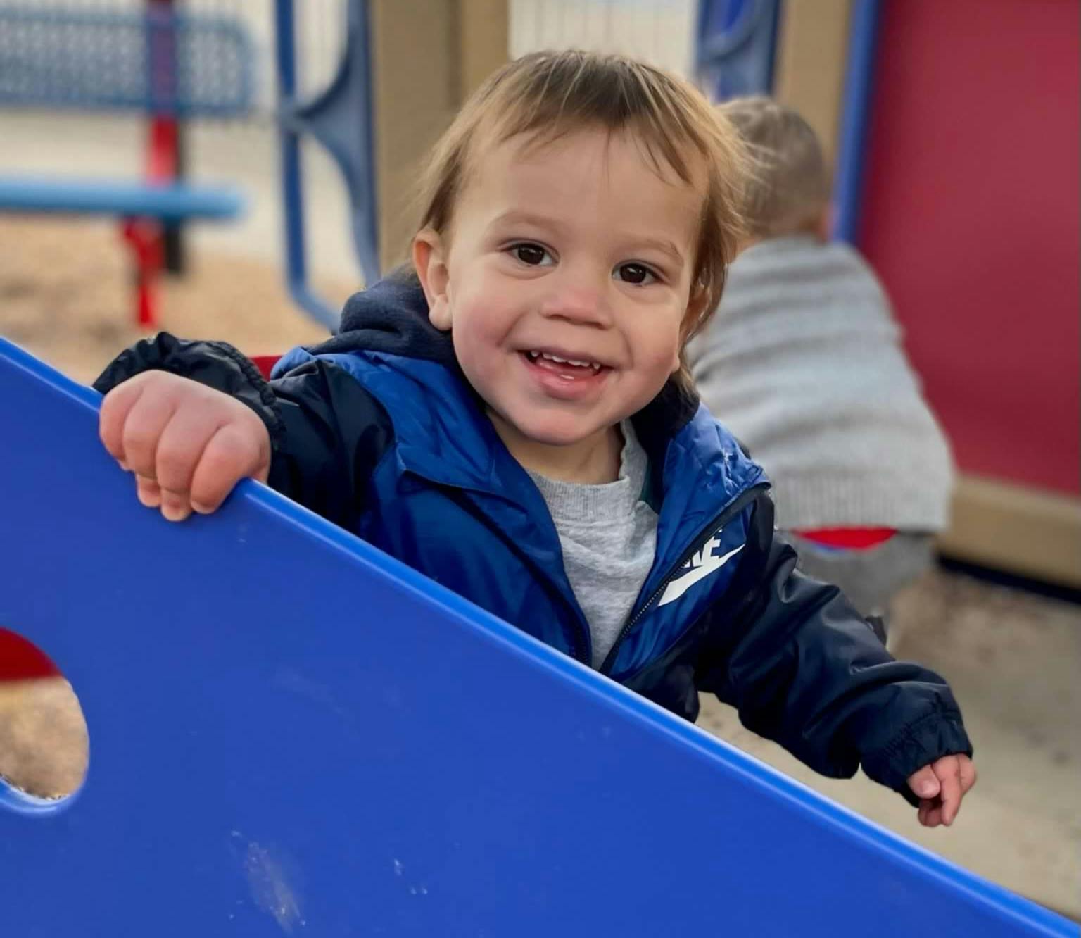 Child on a blue slide at a playground