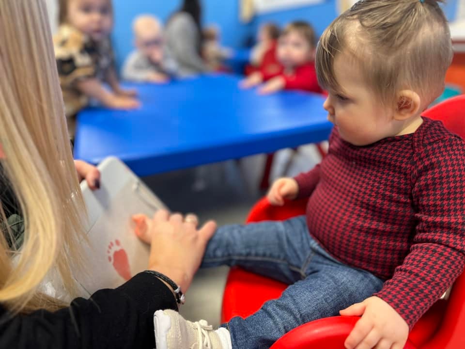 Person holding a child's foot in a classroom