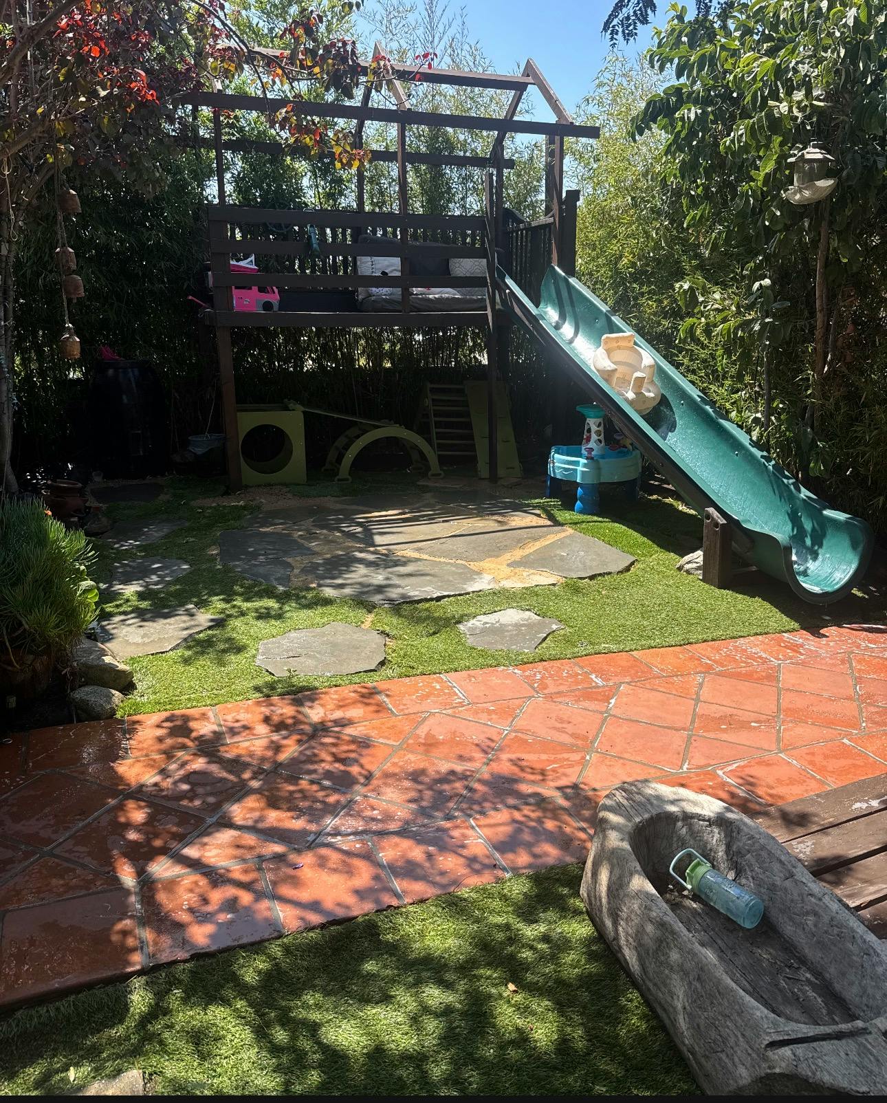 backyard play structure with a slide and climbing areas