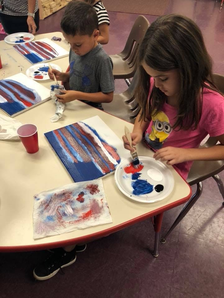 Two children painting at a table