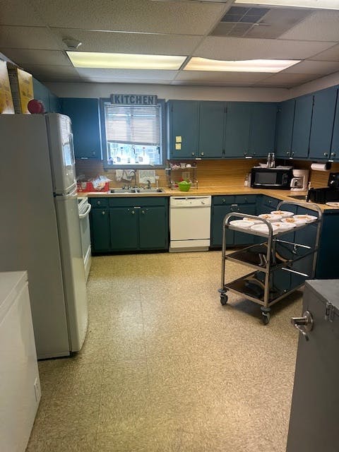 Kitchen with blue cabinets, white appliances, and a serving cart