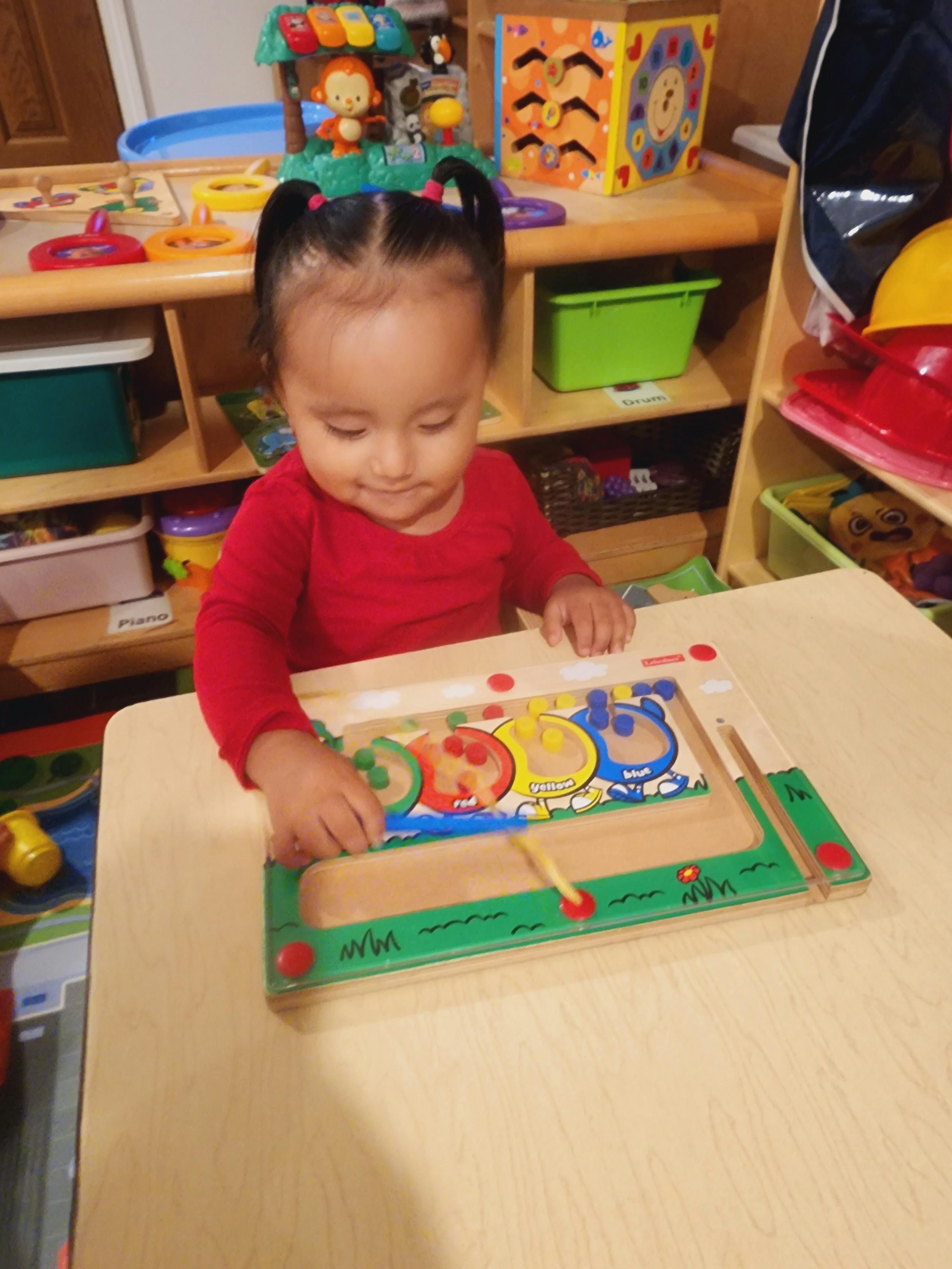 Child playing with a wooden puzzle on a table