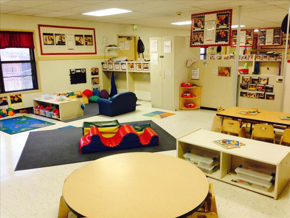 An empty early childhood classroom with various learning and play areas