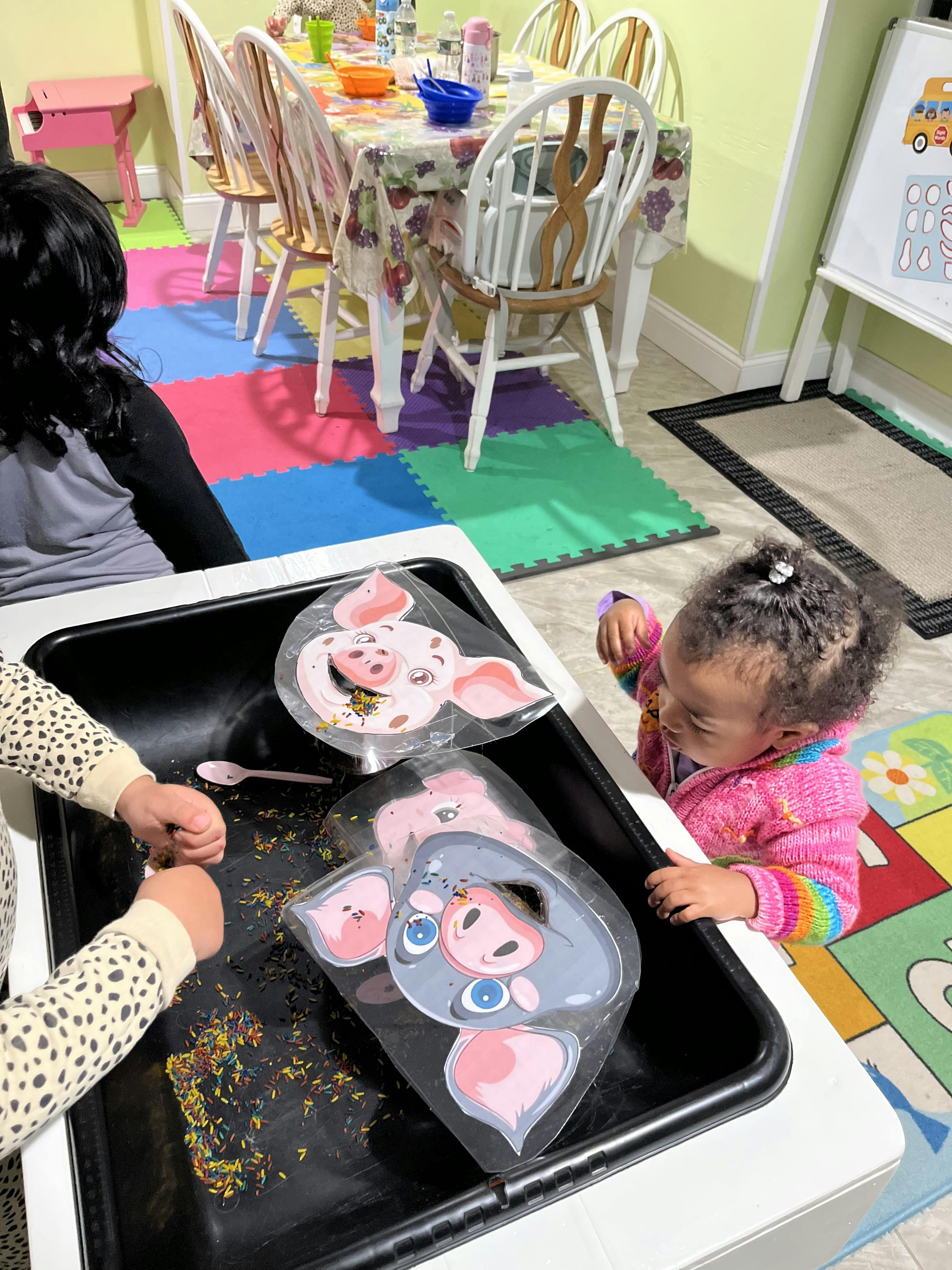 Child playing with sensory bin with pig-shaped bags