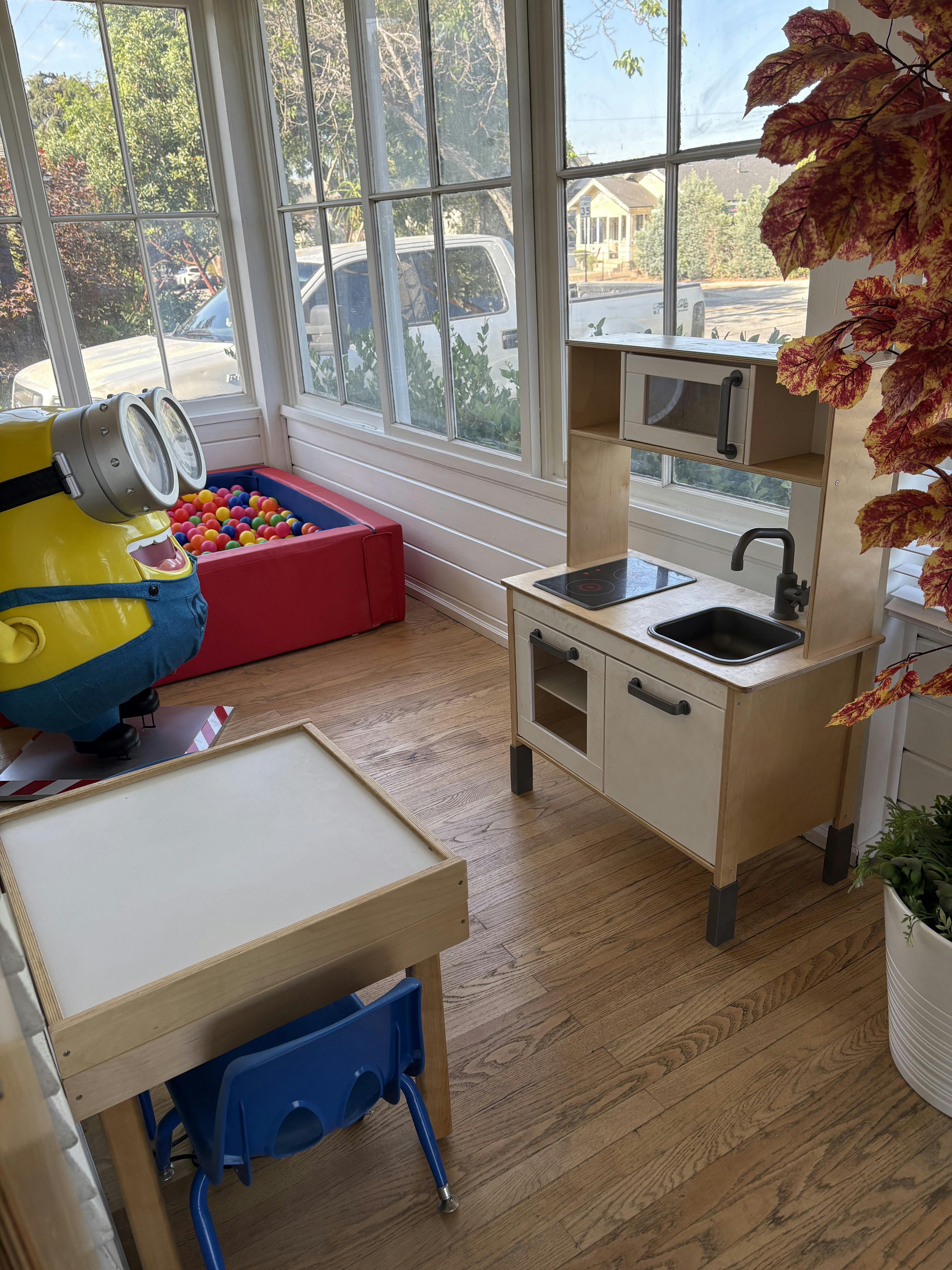 Playroom with a ball pit, toy kitchen, and small table