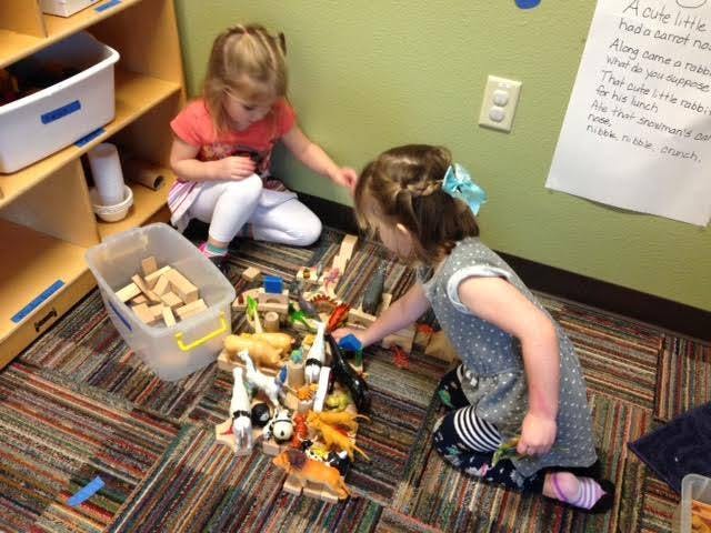 Two children playing with toys on the floor