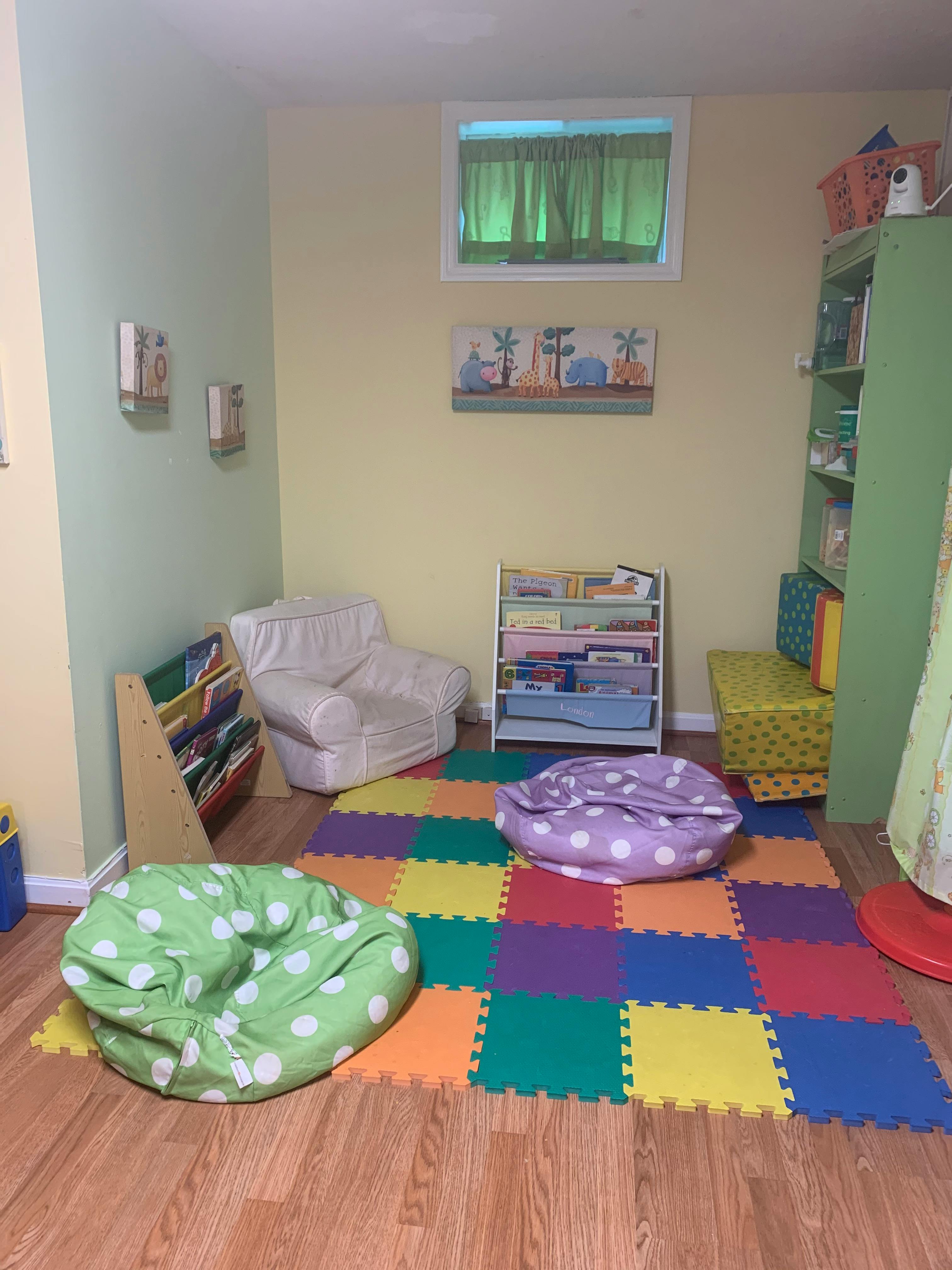 Playroom with colorful floor mats, bean bags, and bookshelves