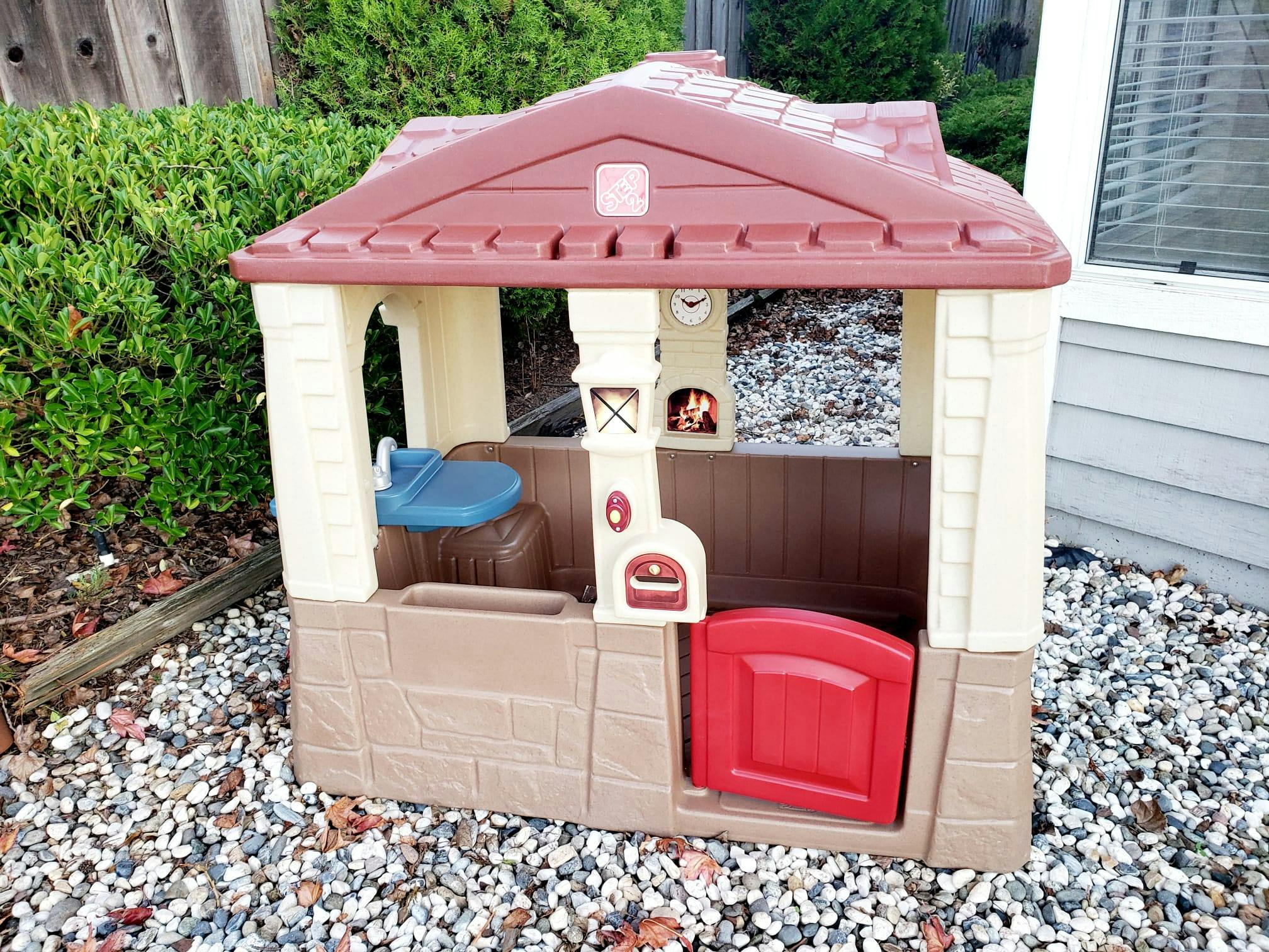 Plastic playhouse with red roof and door