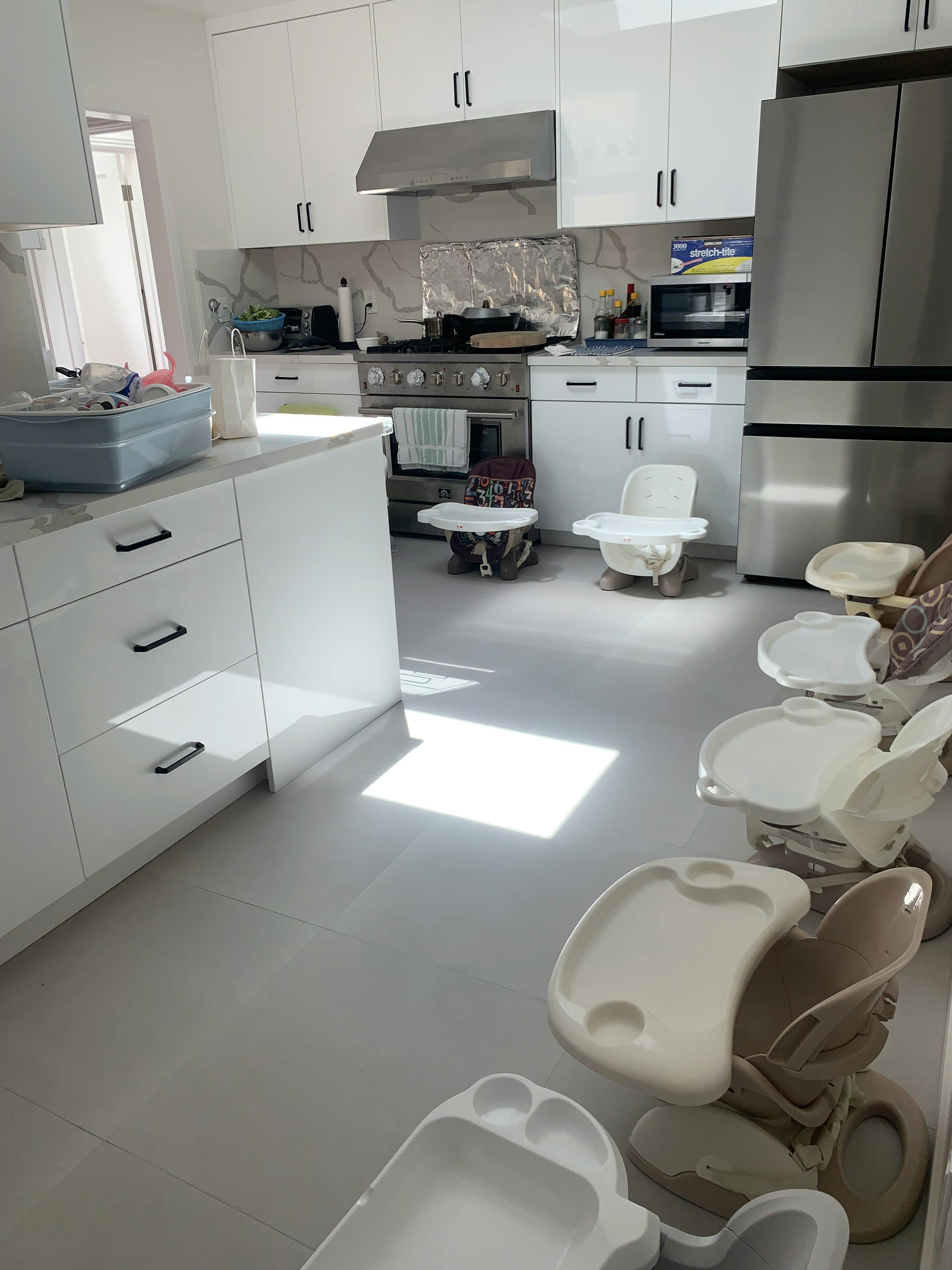 Kitchen with multiple baby high chairs on the floor