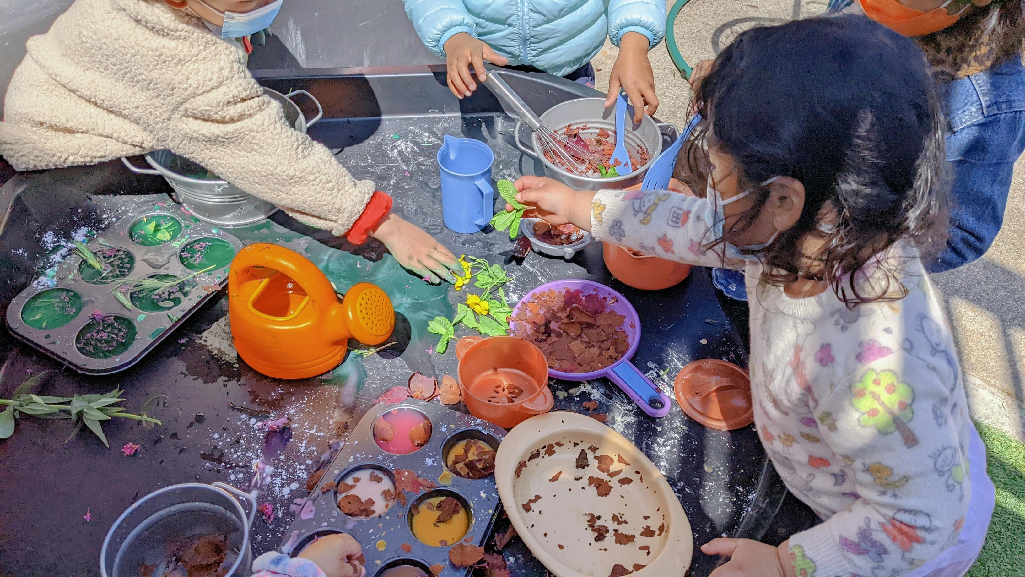 Children playing with water and various objects on a table