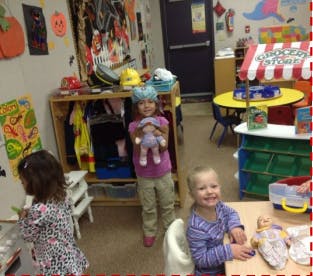 Three children playing in a classroom