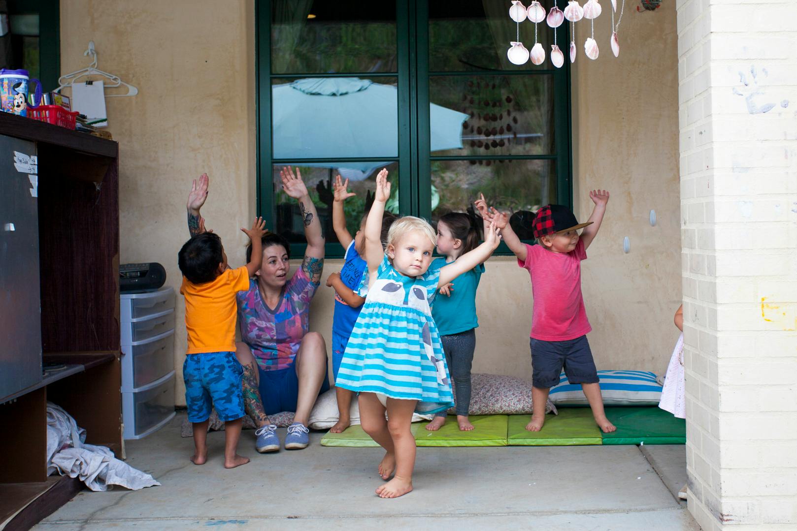 Adult and children with arms raised