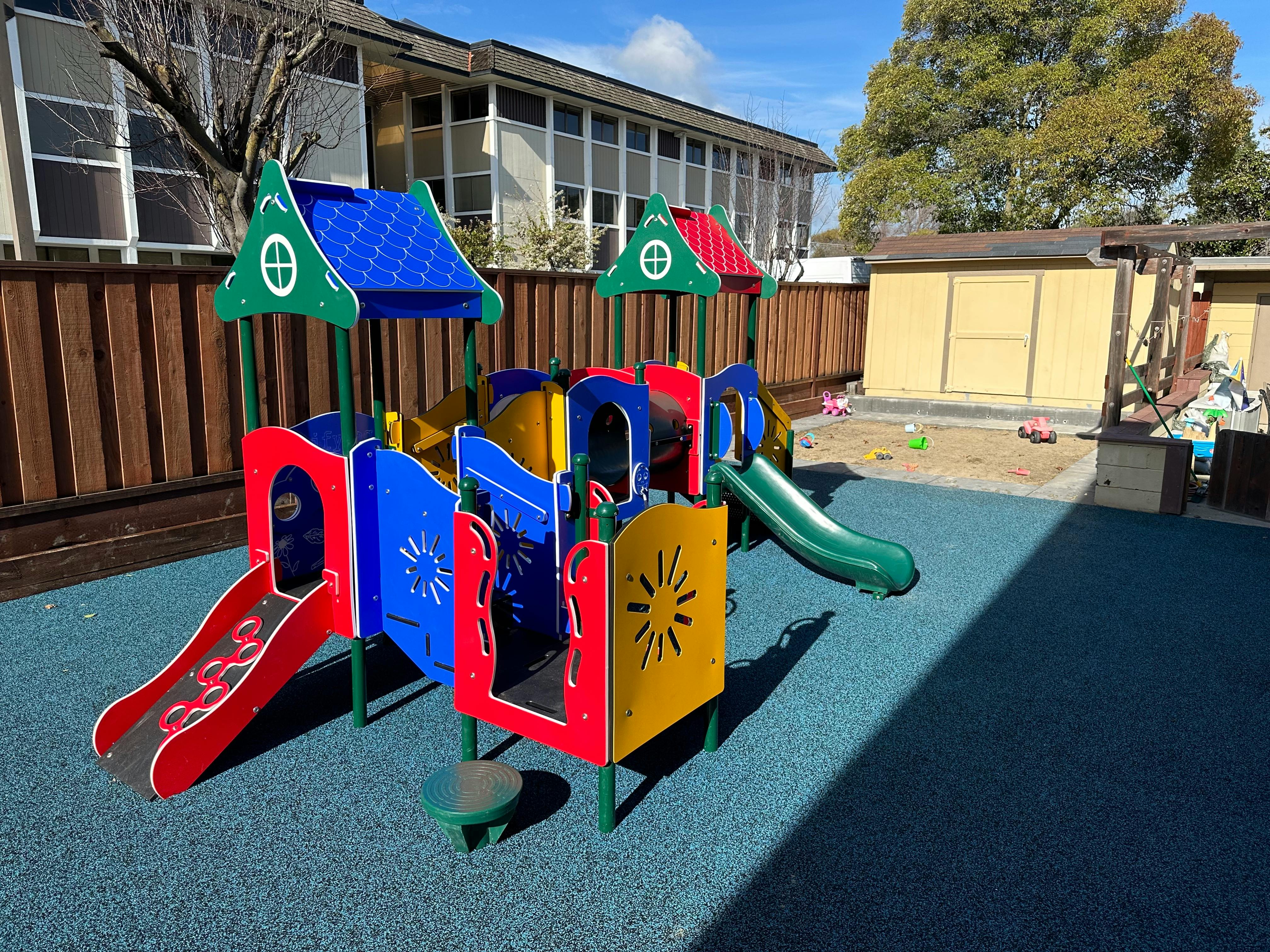 Colorful playground structure with slides on a blue soft surface
