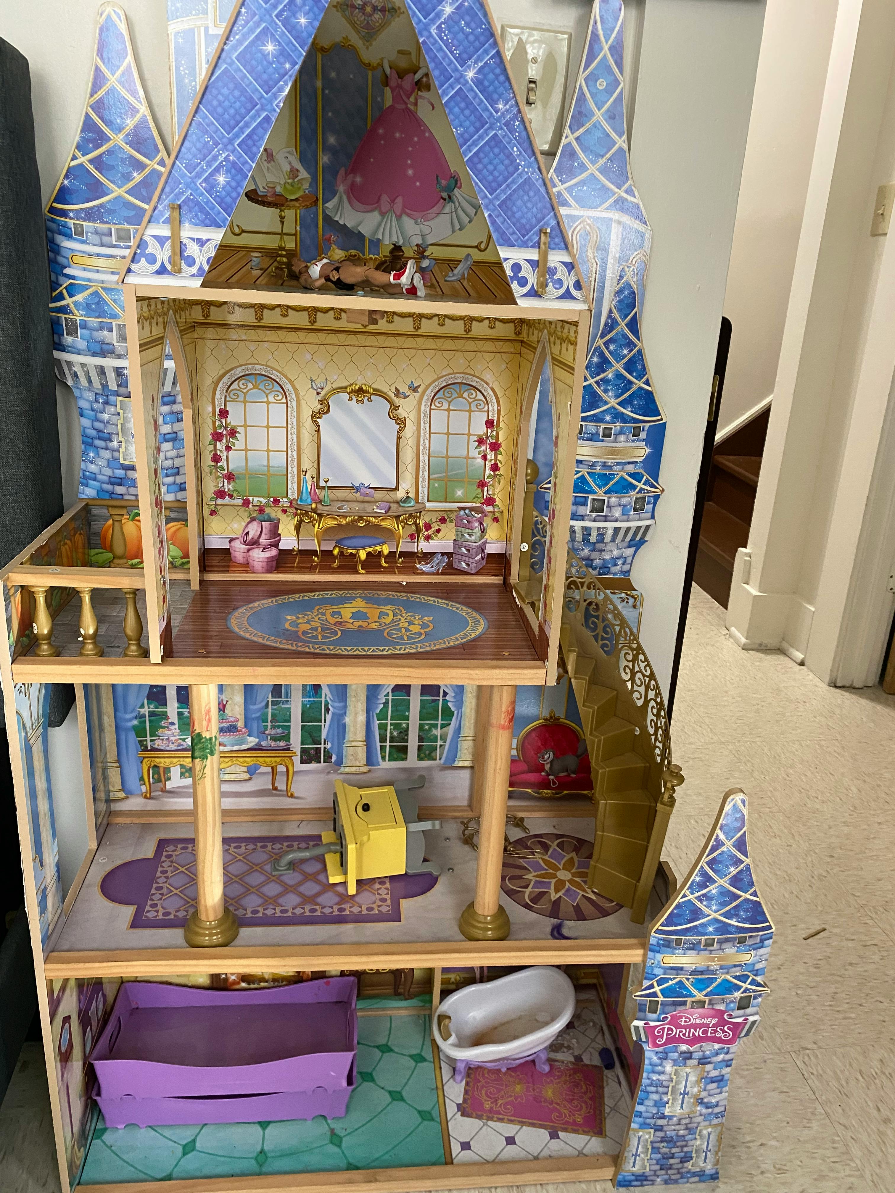 Multi-story dollhouse with blue roofs and various miniature furniture