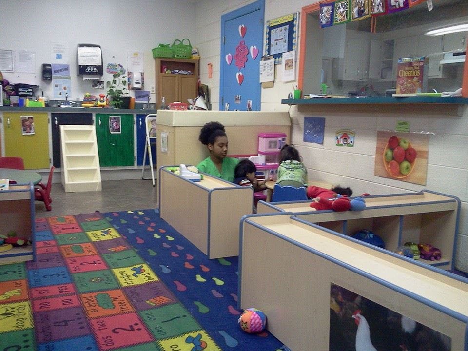 Adult and child playing in a classroom