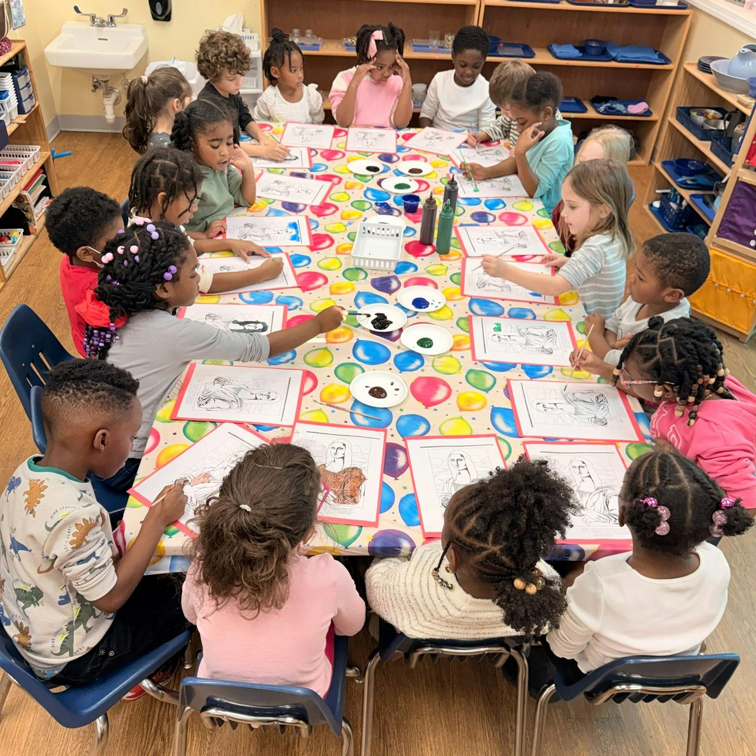 Group of children seated at a table coloring pictures of the Mona Lisa