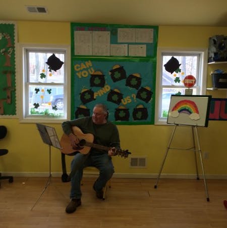 Person playing an acoustic guitar in a room
