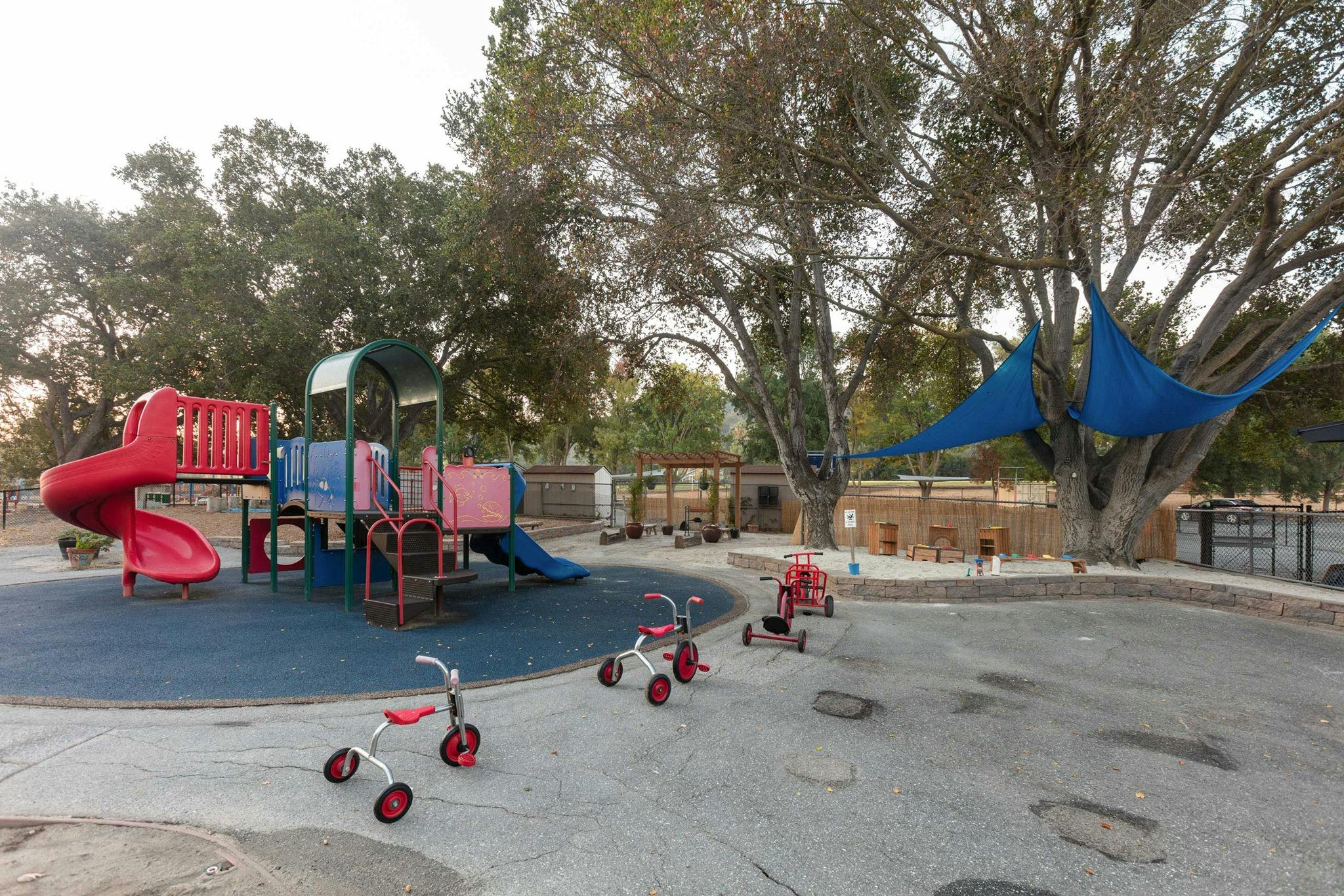 Playground with slides, climbing structure, and tricycles