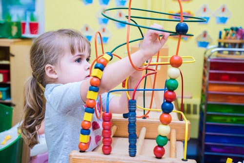 Child playing with a bead maze toy