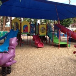 Playground with slides and climbing structures under a blue shade