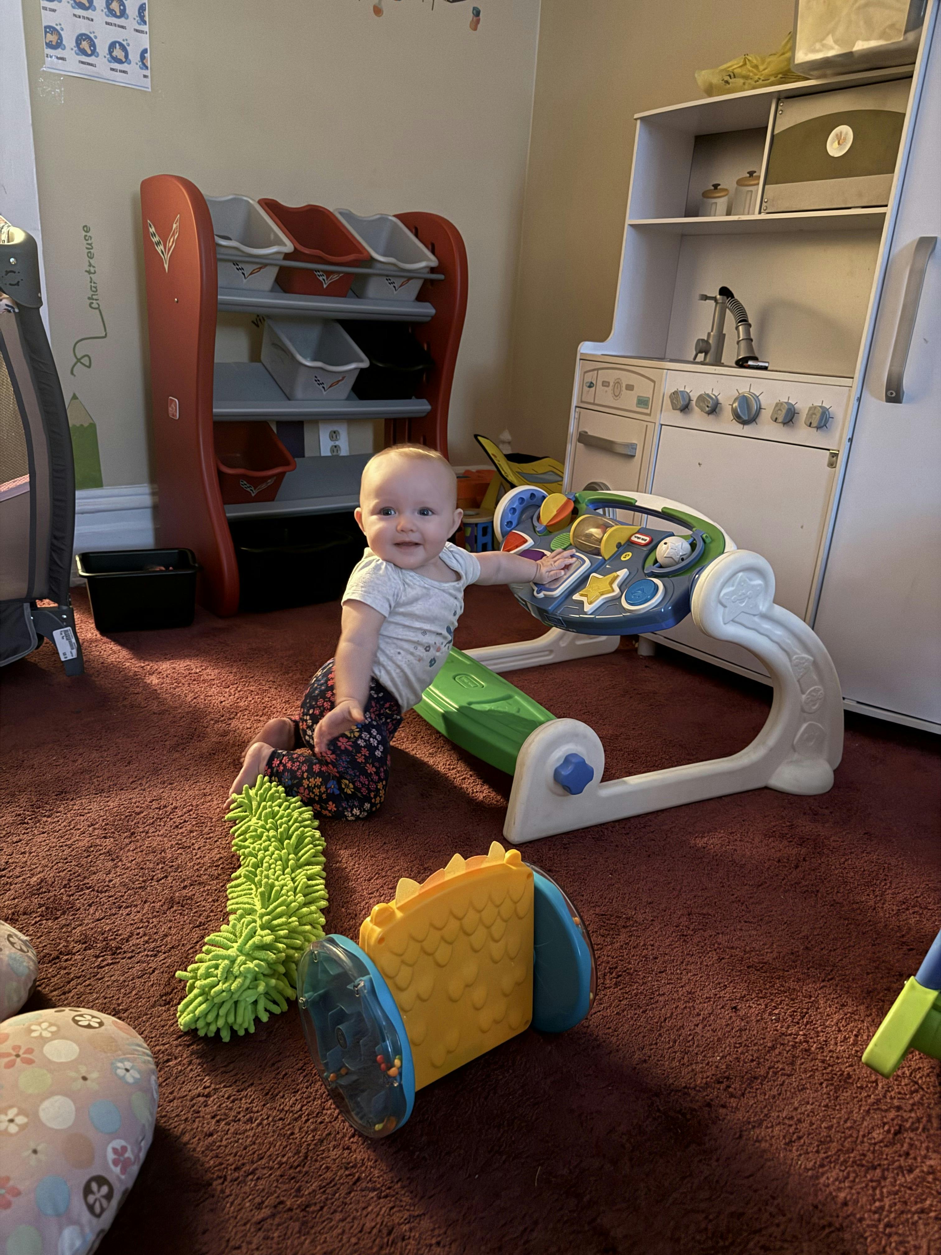 Child playing with a toy activity center on a carpeted carpet