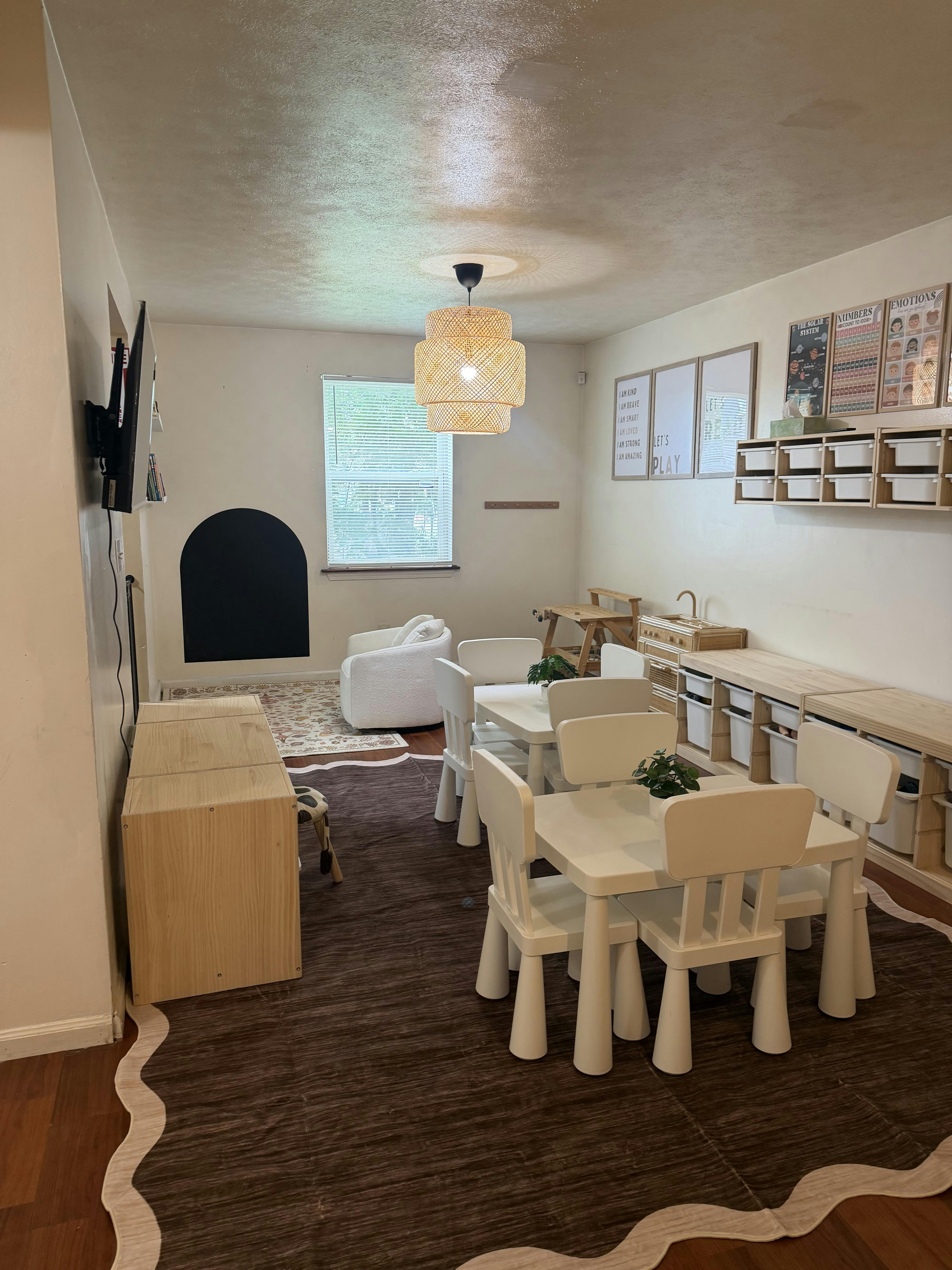 Playroom with children's tables and chairs storage units and wall charts