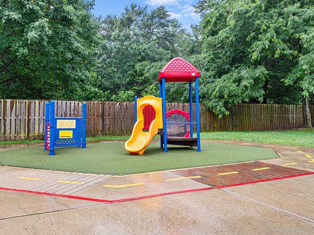 Colorful playground equipment with a yellow slide on artificial turf